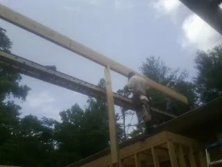 Carpenter setting a ridge beam over a new addition frame — Ice Dam Removal by Roofing Brothers in Dunnsville