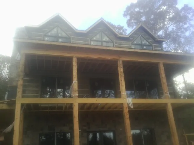 Dormers and porch framing on a large log home under construction — Roof Coating work by our crew in Dunnsville